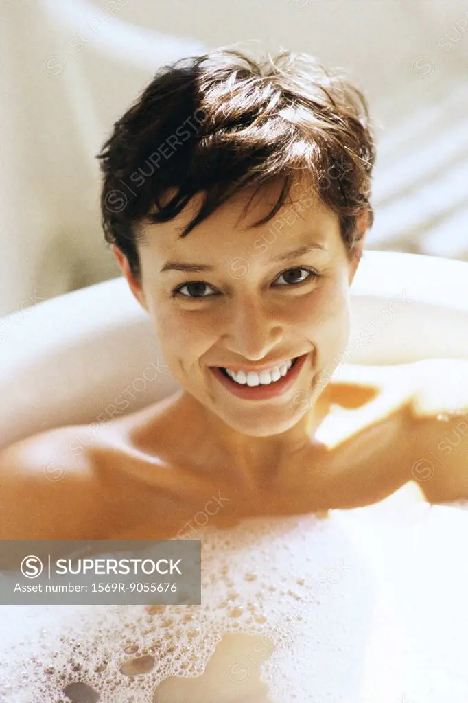 Woman enjoying bath, smiling at camera