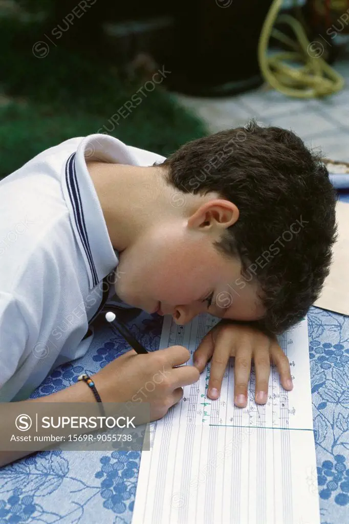 Young boy correcting music homework