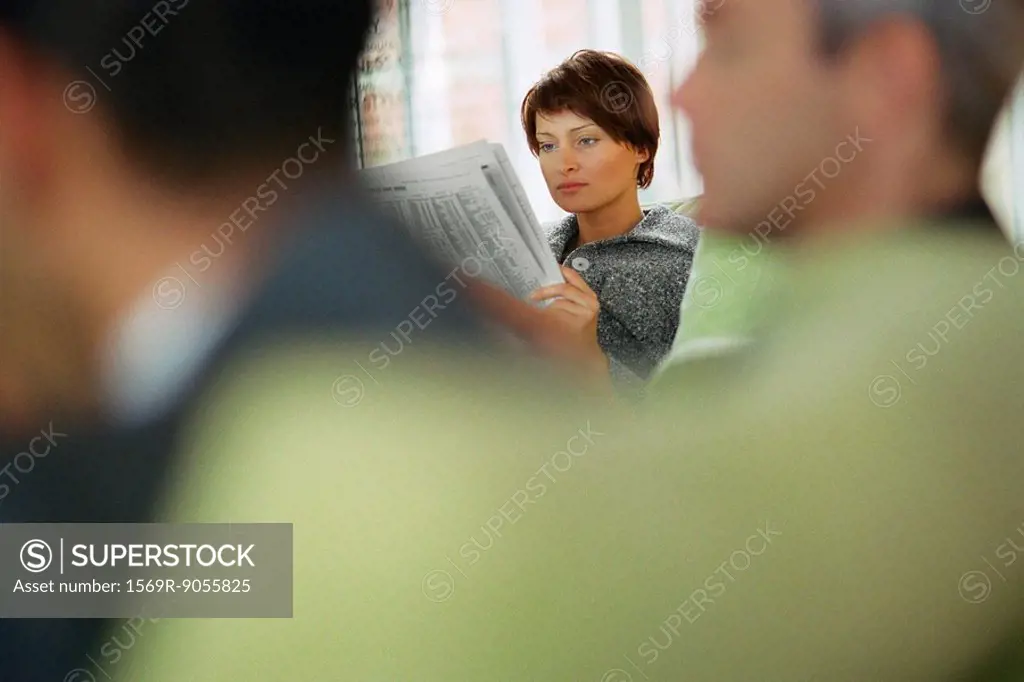 Businesswoman reading newspaper in waiting room