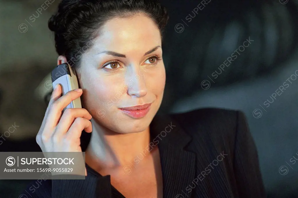 Young businesswoman using cell phone, smiling