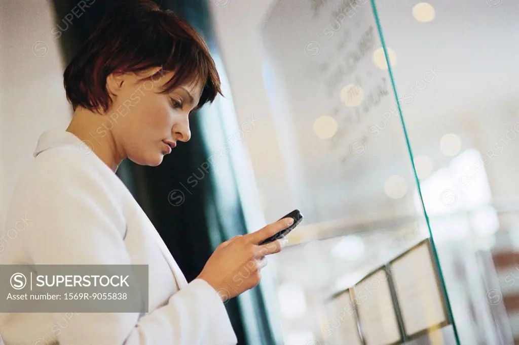 Businesswoman looking at cell phone, side view