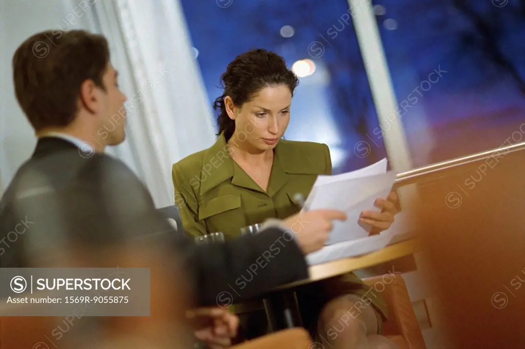Business associates discussing contract at table