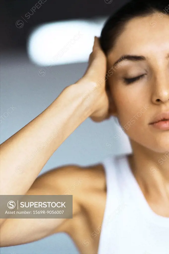 Woman with eyes closed holding head