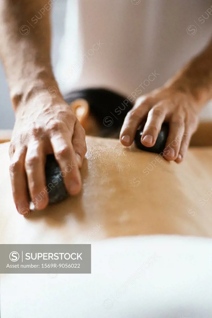 Lastone therapy, therapist placing stones on patient´s bare back