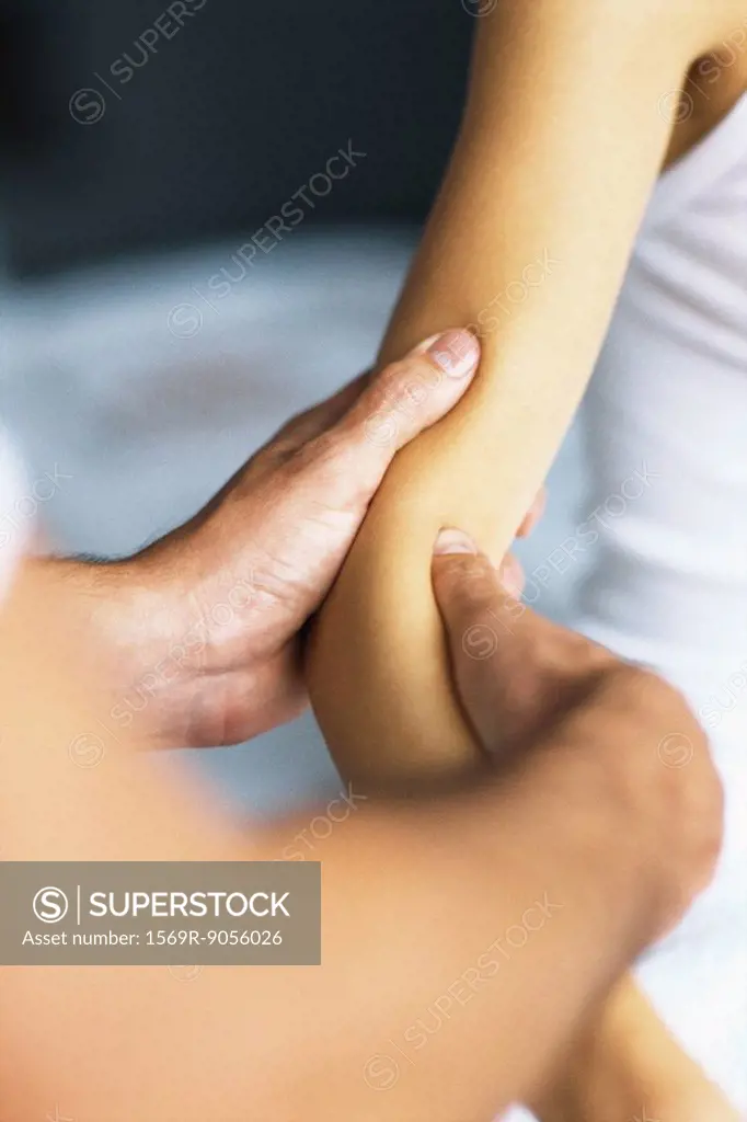 Massage therapist massaging patient´s arm