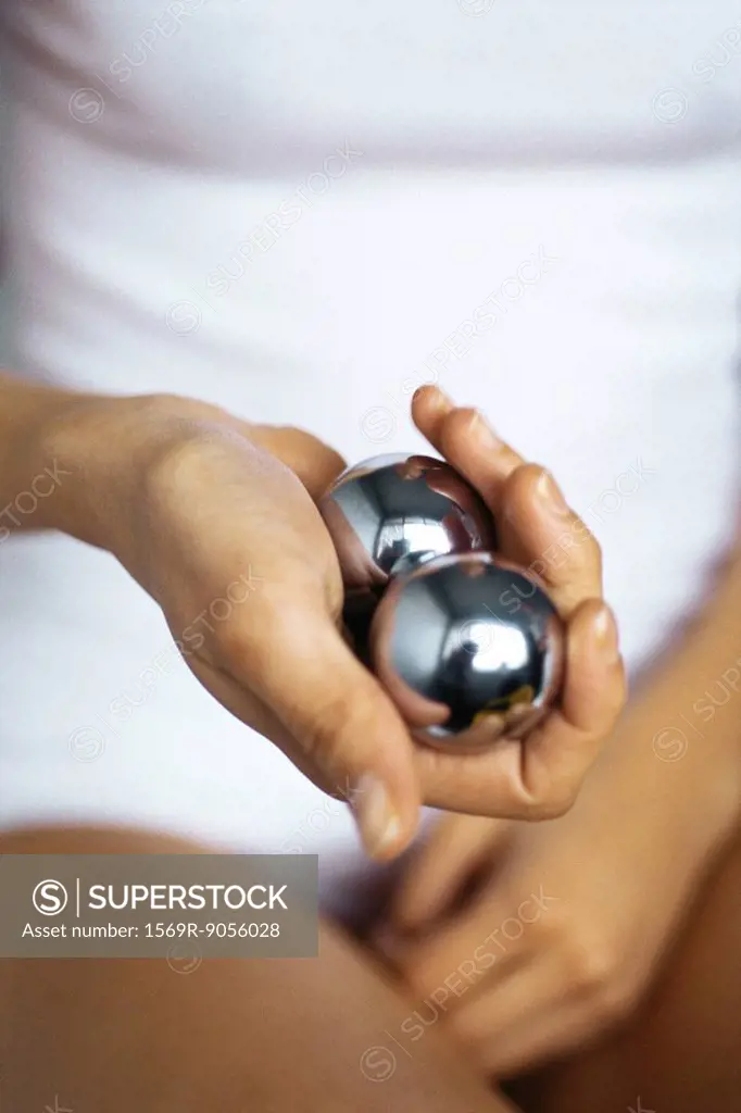 Woman holding yin yang balls, cropped
