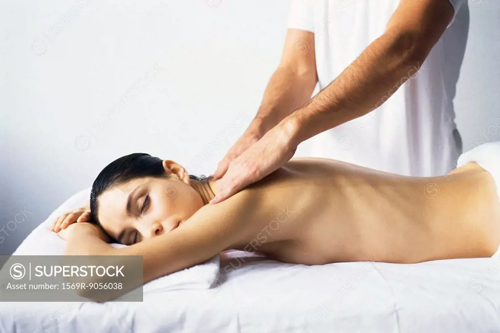 Massage therapist massaging woman´s shoulders