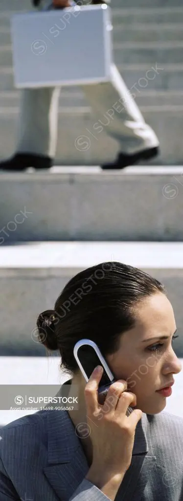 Businesswoman using cell phone, looking away