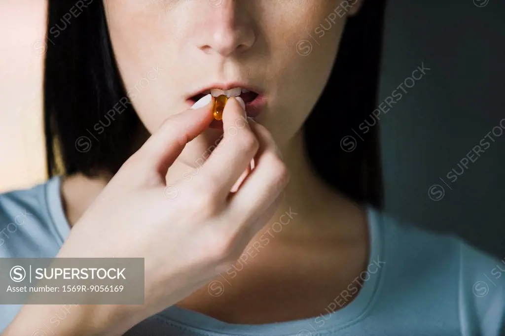 Woman taking vitamins, close_up