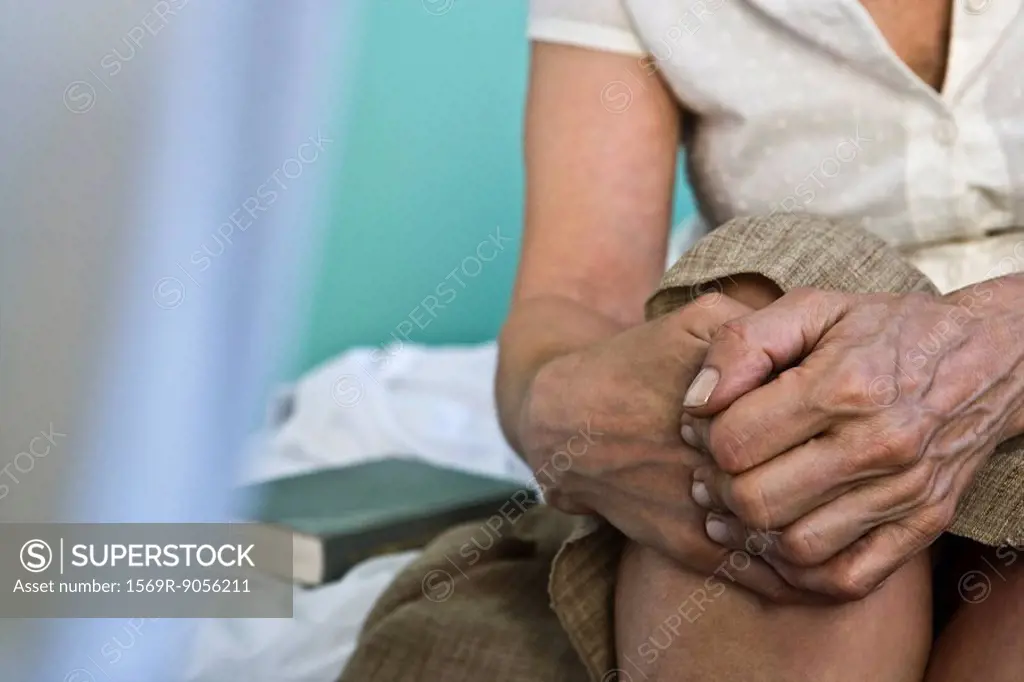Woman´s hands clasped on knee, close_up