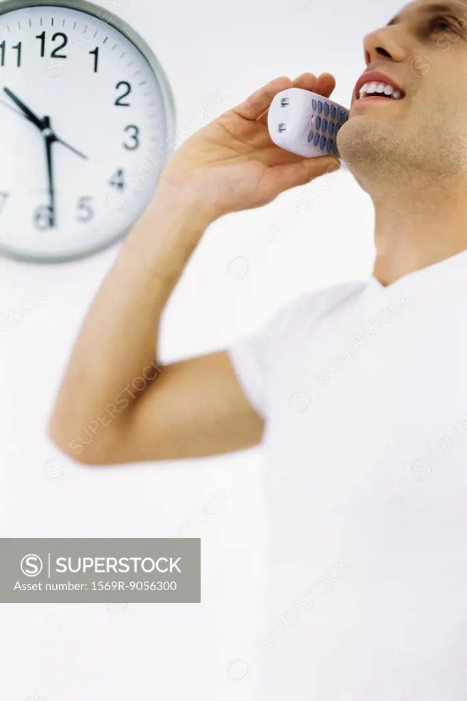 Man on phone call, clock in background