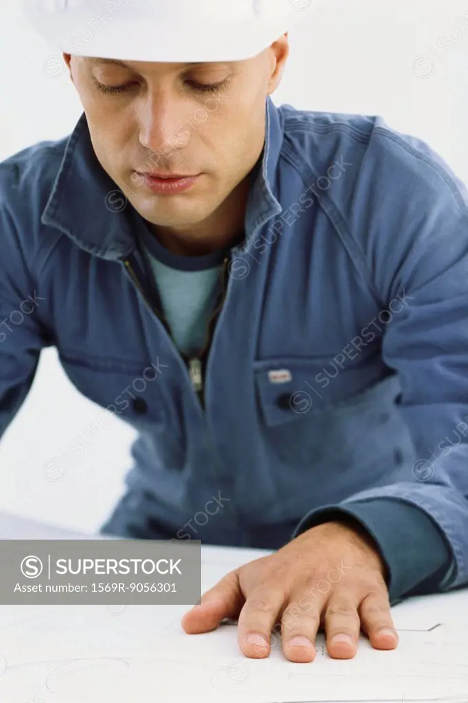 Handyman looking at blueprints