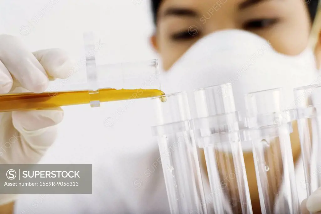 Laboratory technician transferring liquid to test tube