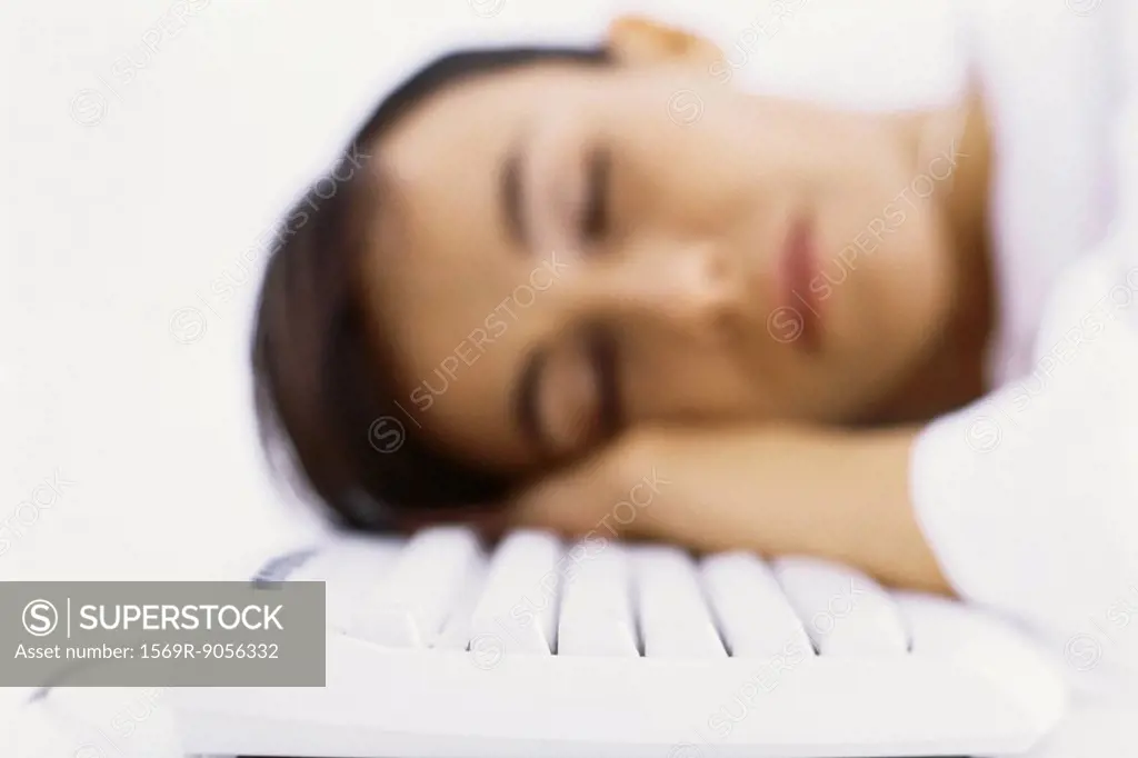 Woman asleep, resting head on computer keyboard