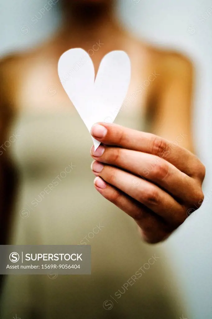 Woman´s hand holding out paper heart