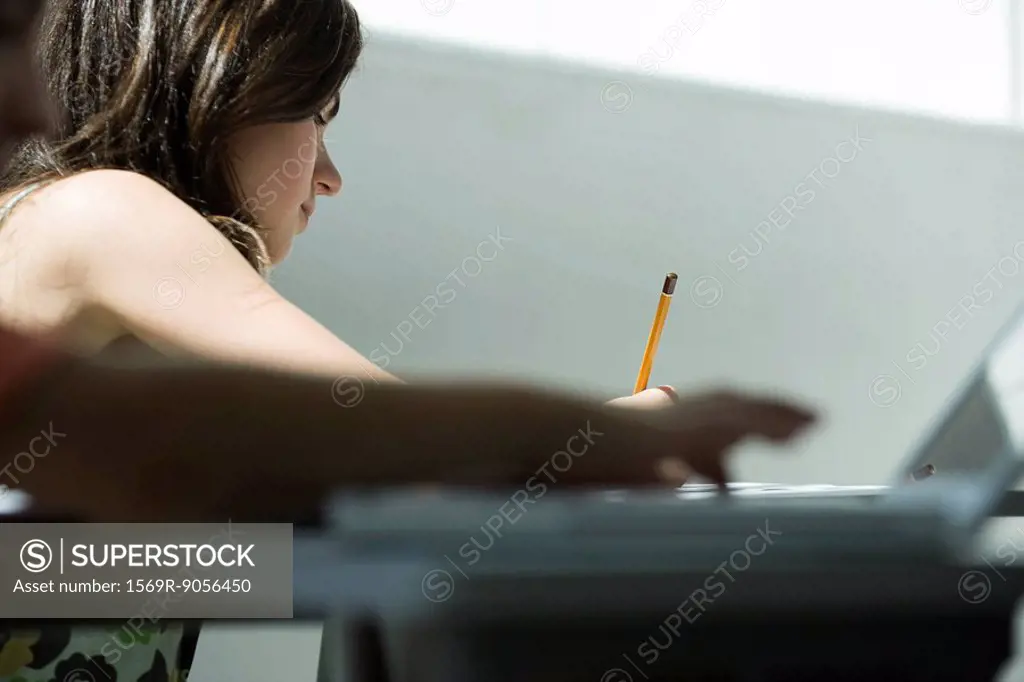 Teenage girl writing at desk