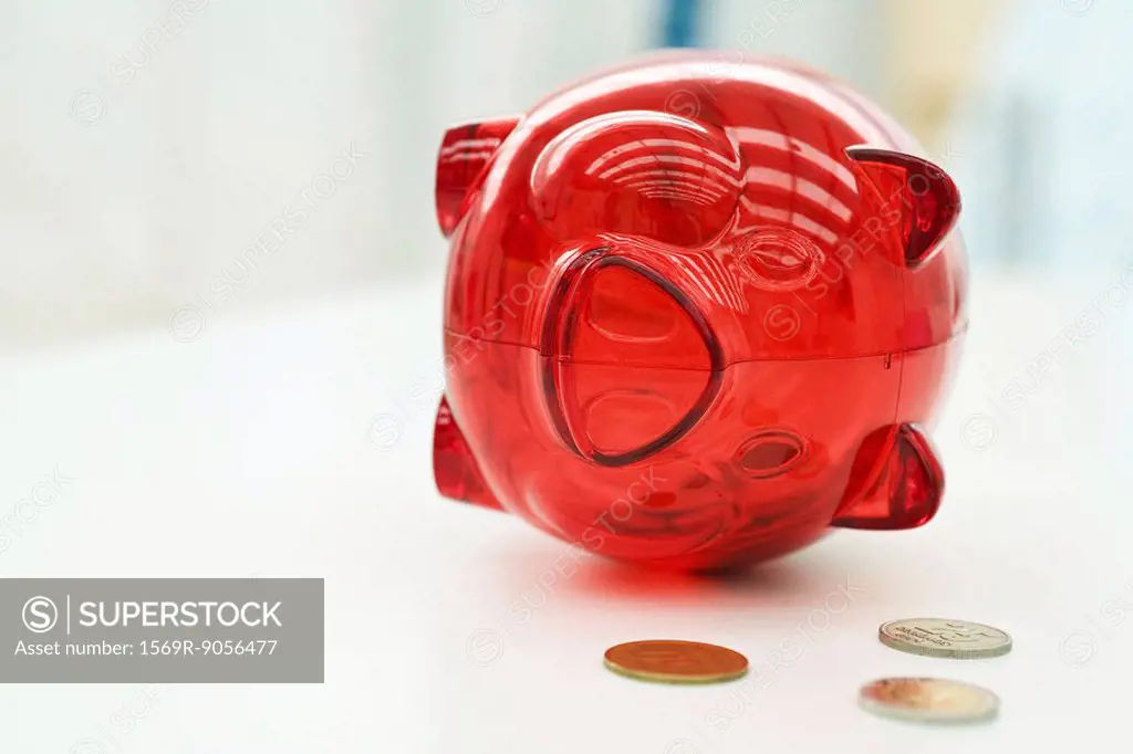 Piggy bank lying on side, coins nearby