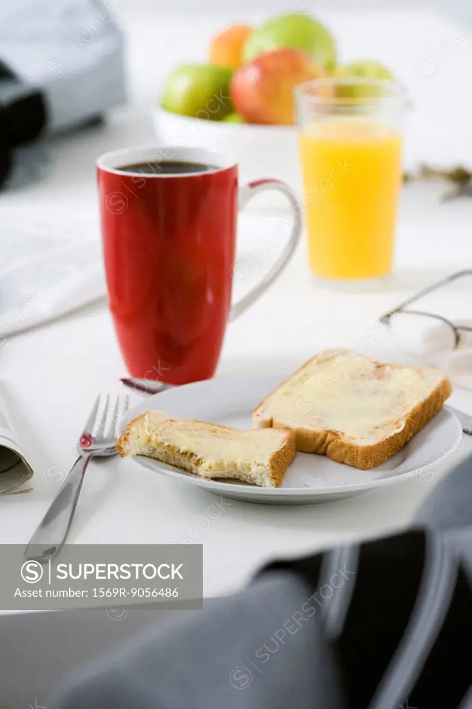 Breakfast consisting of buttered toast, coffee and orange juice