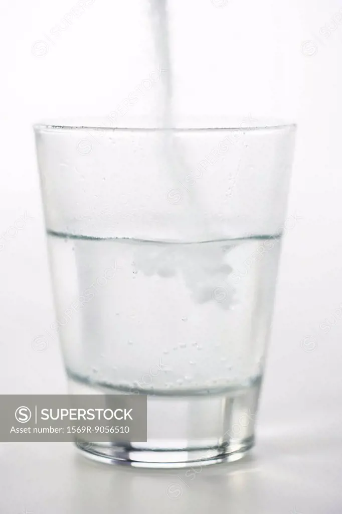 Pouring powdered medicine into glass of water