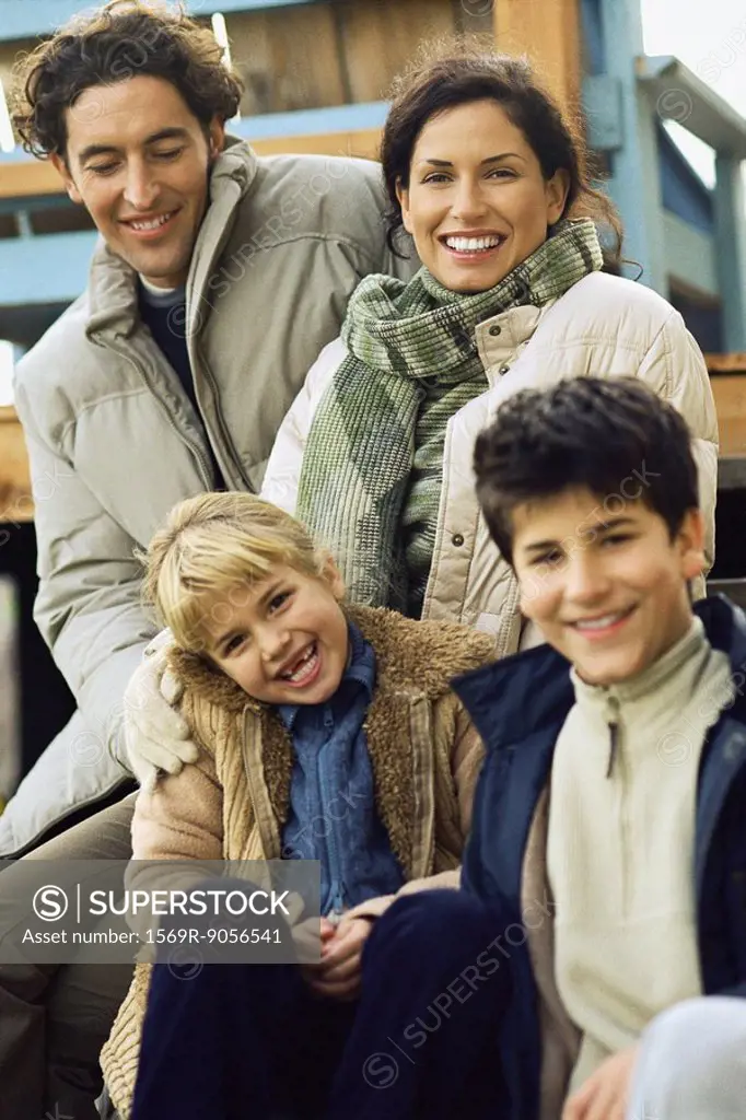 Family sitting together on deck, portrait