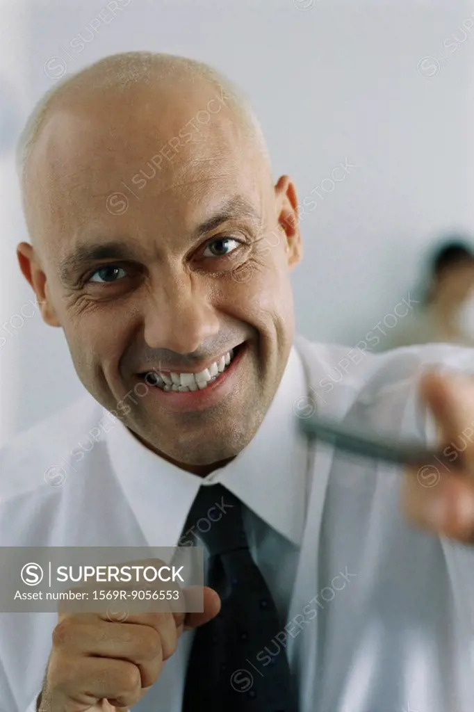 Businessman clenching fists, smiling at camera