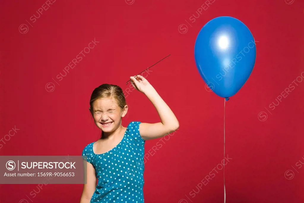 Girl preparing to pop balloon