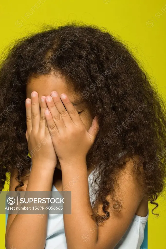 Little girl covering face with hands