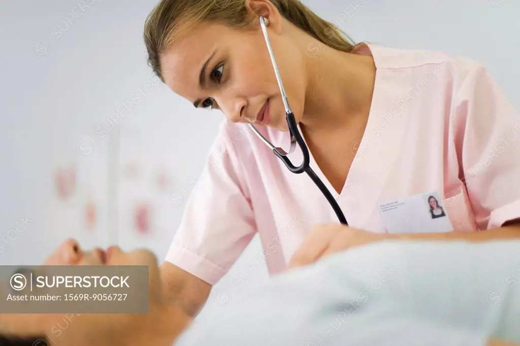 Nurse listening to male patient´s chest with stethoscope