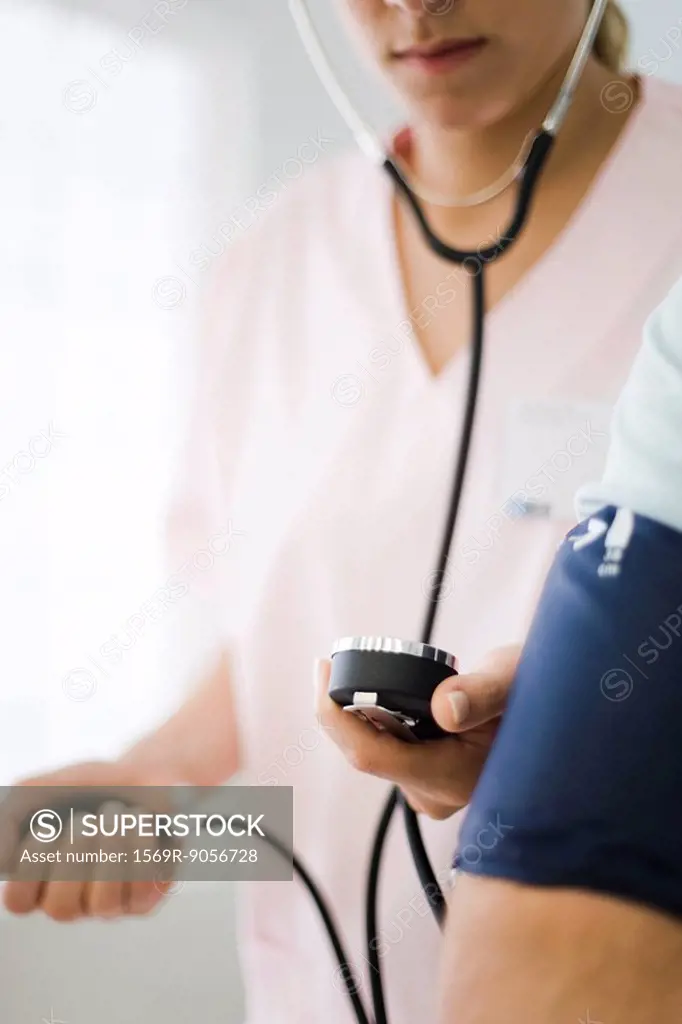 Nurse checking patient´s blood pressure, cropped