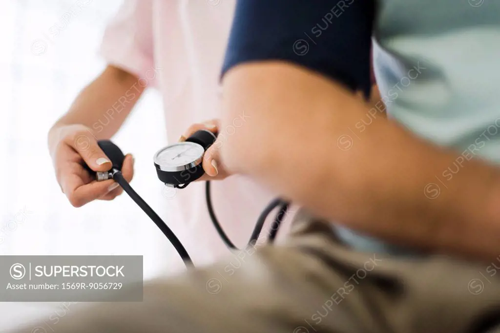 Nurse checking patient´s blood pressure, cropped