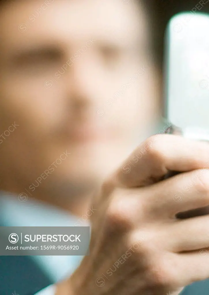 Businessman holding out cell phone