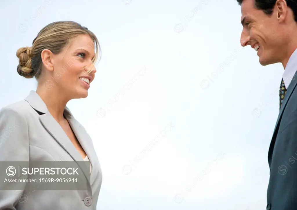 Businesswoman and businessman smiling at each other