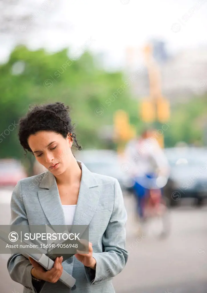 Businesswoman looking at agenda in street