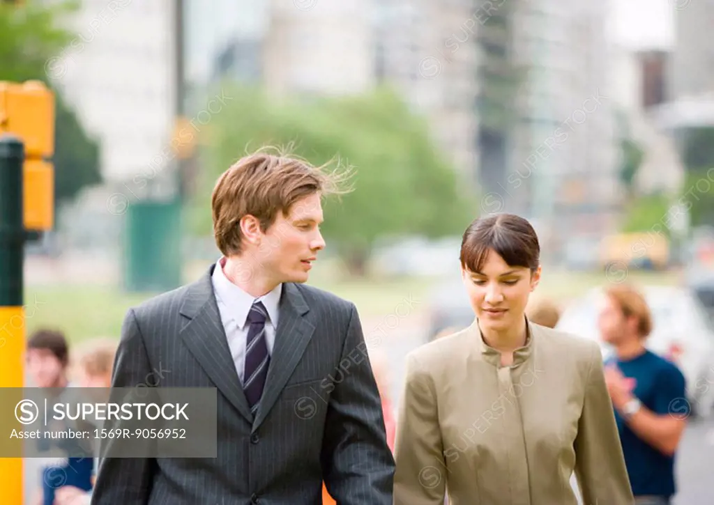 Young businessman walking with female collegue
