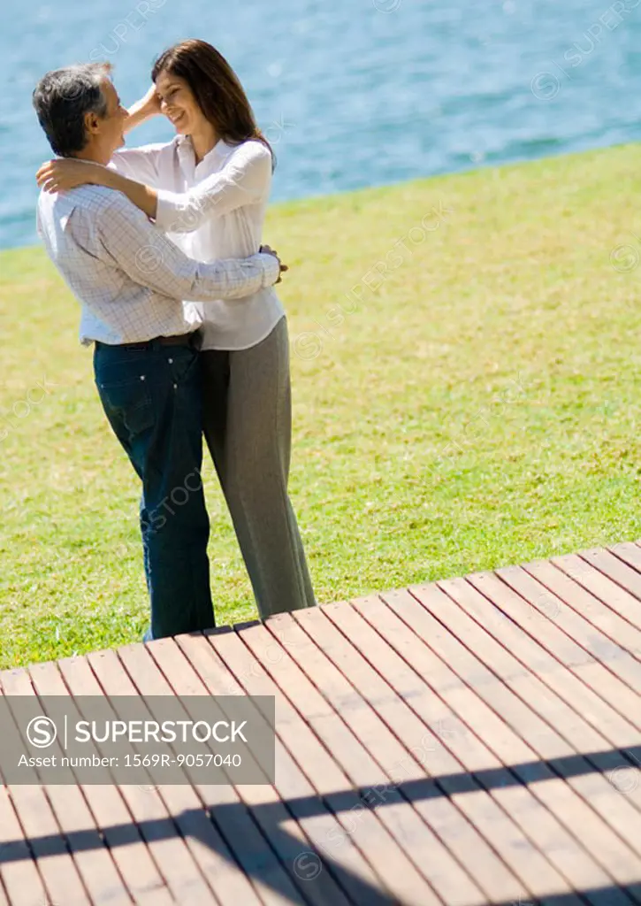 Couple standing in each other´s arms near lake