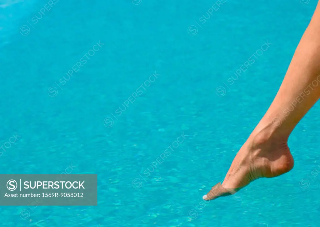 Woman´s foot, testing water in pool