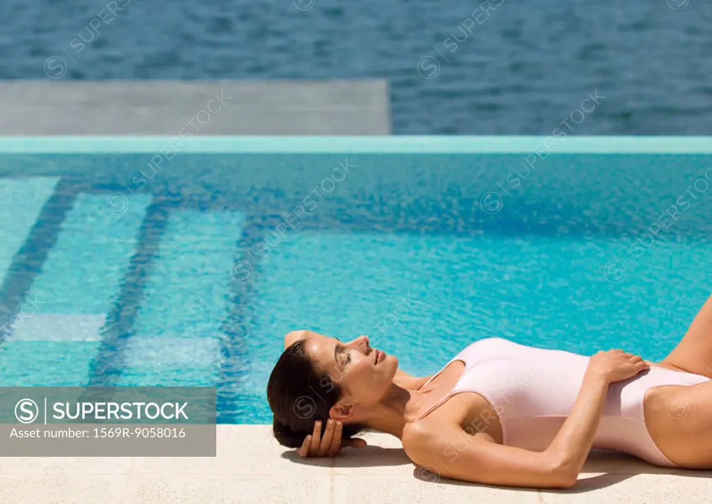Woman lying by pool in sun