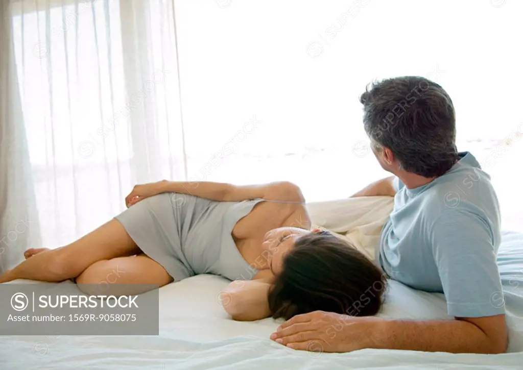 Adult couple lying on bed