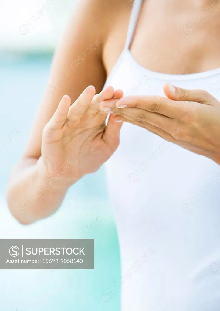 Woman applying moisturizer to hands