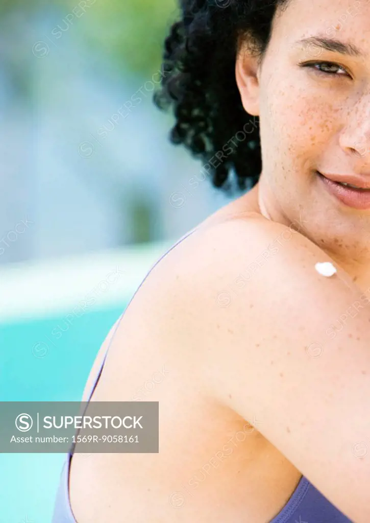 Young woman with dab of sunscreen on shoulder