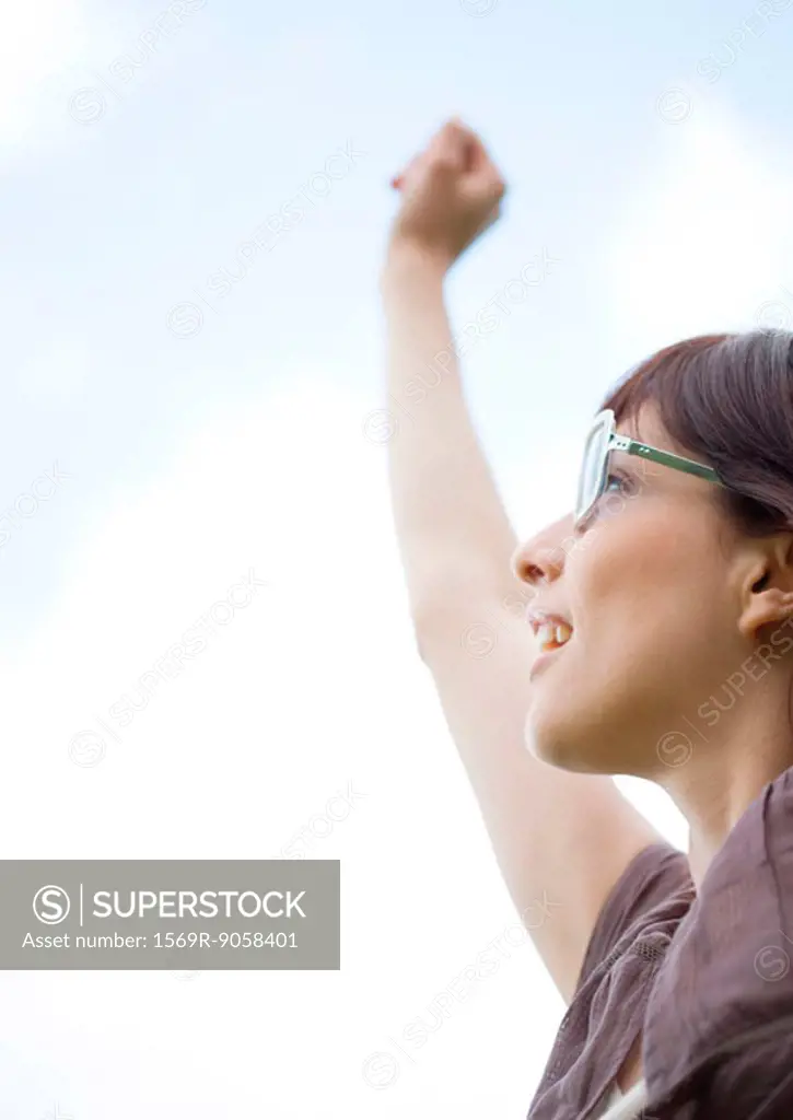 Woman wearing glasses, reaching arm upward