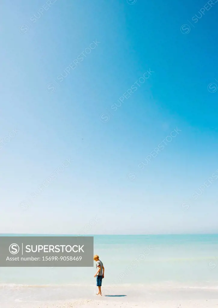 Child standing on beach in mid-distance