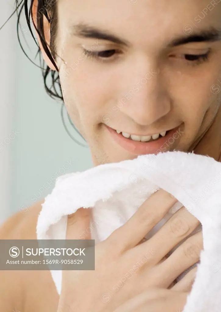 Man smiling and drying off with towel, close-up