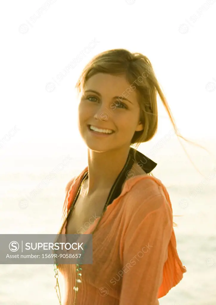 Woman smiling, sea in background