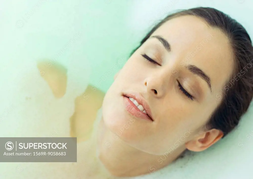 Woman reclining in bath, eyes closed