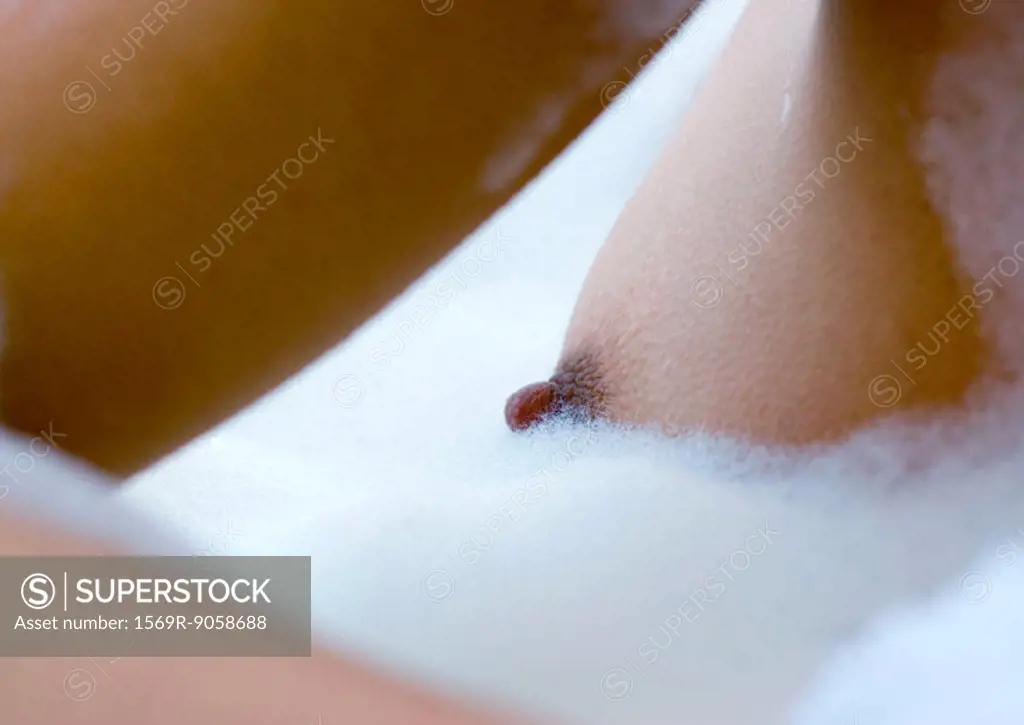 Woman´s breast in bubble bath