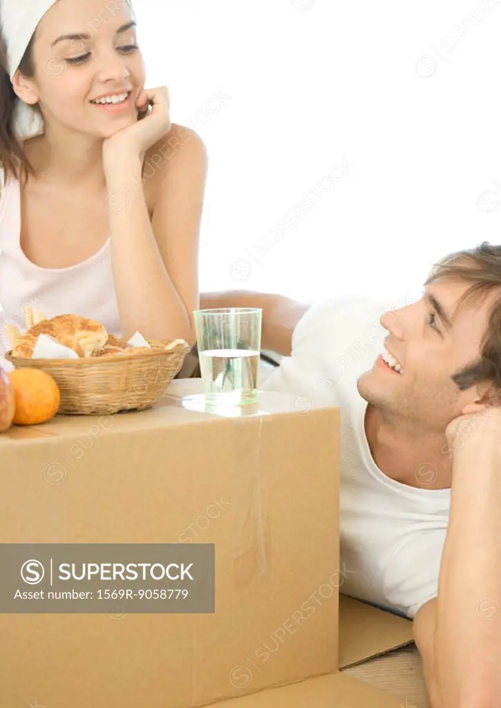 Couple having breakfast on cardboard box