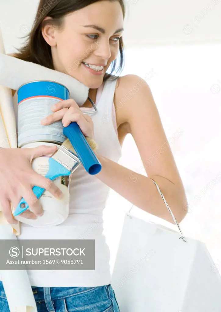 Woman holding armload of painting supplies