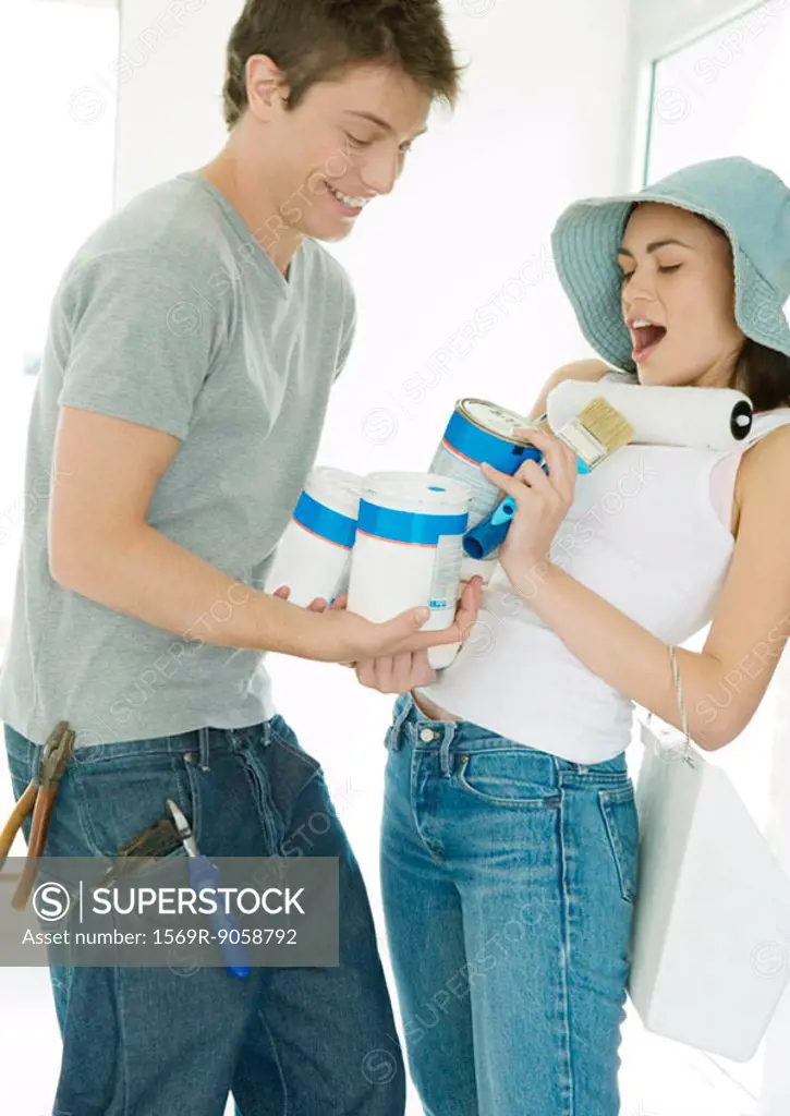 Couple holding painting supplies