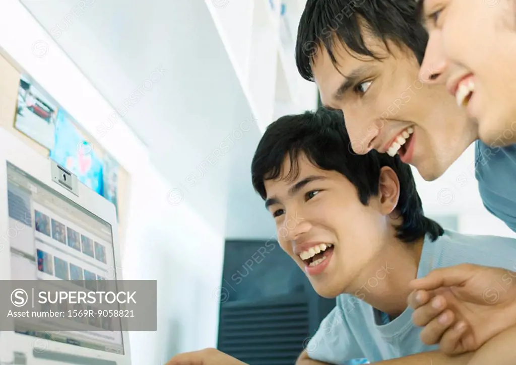 Three young friends looking at computer screen